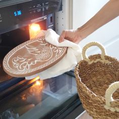 someone is cleaning an oven with a cloth and basket in front of the oven door