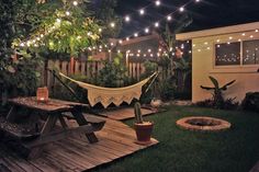 an image of a backyard at night with lights on the trees and hammock