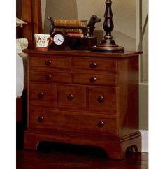 a wooden dresser with a lamp on top of it