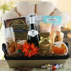 a gift basket filled with champagne, chocolates and candies next to a teddy bear