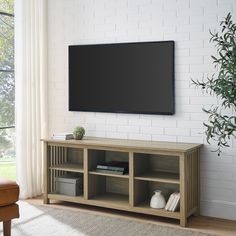 a flat screen tv mounted to the side of a wooden entertainment center in a living room