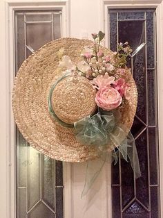 a straw hat with flowers on the front door