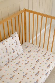 a crib with a sheet and pillow on it