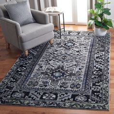 a living room area with a chair, rug and potted plant on the floor