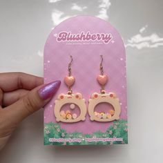 a pair of pink earrings with hearts on them