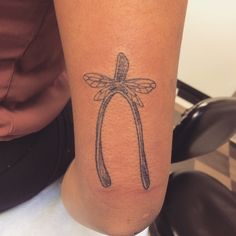 a woman's arm with a tattoo on it that has a dragonfly on it