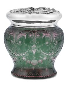 a green and silver vase sitting on top of a table