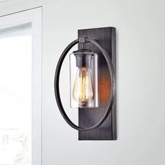 a light that is on the wall next to a window in a room with white walls