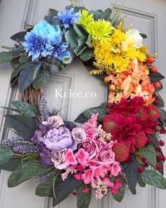 a colorful wreath with flowers on the front door