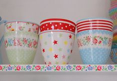 colorful cups are lined up on a shelf