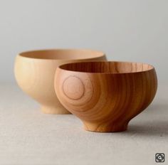 two wooden bowls sitting next to each other