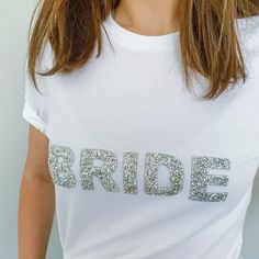 a woman wearing a white t - shirt with the word bride printed on it's chest