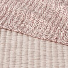 a close up view of a pink and white blanket