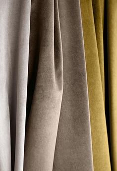 several different colored fabrics hanging on a rack