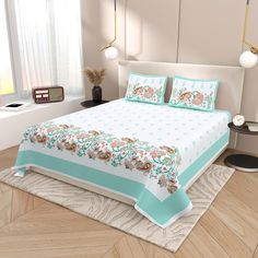 a bed with blue and white bedspread on top of a wooden floor next to a window