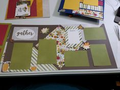 the table is covered with many different papers and crafting supplies, such as scrapbook pages