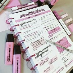 the contents of a pink planner spread out on a table with pens and highlighters