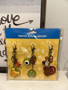 three keychains with charms in the shape of disney's characters on them