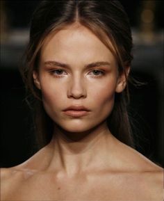 a close up of a woman's face on the runway