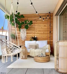 an outdoor living area with hammock chairs and wicker hanging from the ceiling