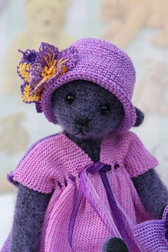 a teddy bear wearing a purple dress and hat