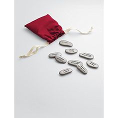 a group of buttons sitting on top of a white table next to a red bag