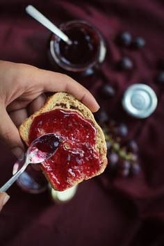 a person holding a spoon with jam on it