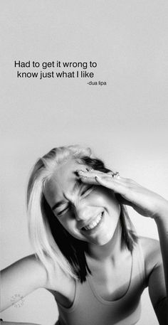 a black and white photo of a woman with her hand on her head, smiling