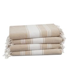 three towels stacked on top of each other with fringes around the edges and one folded in