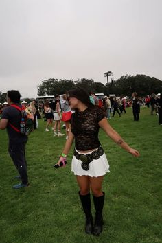 a woman standing on top of a lush green field next to a group of people