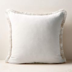 a white pillow with ruffled edges on a table