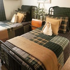 there are two beds in the room with plaid blankets on them, and one has a teddy bear