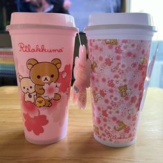 two coffee cups sitting on top of a wooden table