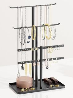 a jewelry stand with several necklaces and earrings on it's display shelf,