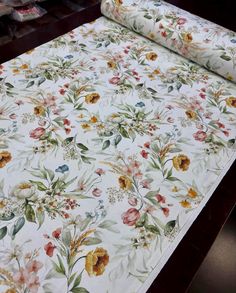 a roll of white fabric with colorful flowers on it