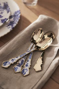 there are spoons and forks on the napkin next to each other in this place setting