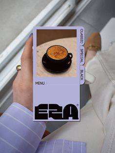 a person holding up a card with an image of a cup of coffee on it