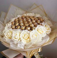 a bouquet of white roses and chocolates in it