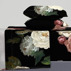 two pieces of black and white floral print wallets, one with pink roses on it