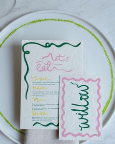 the wedding stationery is hand - lettered with green, pink and yellow ink