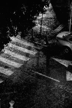 a black and white photo of a car parked in the rain