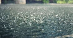 the ground is covered with rain and water droplets as it sits in front of a building