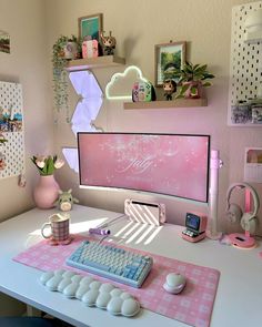 a desk with a keyboard, mouse and phone on it in front of a pink wall