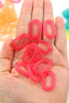 a hand is holding some pink plastic letters