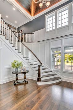 a large foyer with wood floors and white railings on the second floor is shown