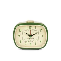 a green and white alarm clock sitting on top of a table