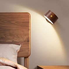 a lamp that is on the side of a bed next to a night stand and nightstand