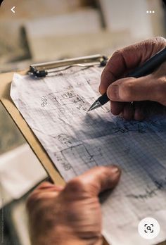 a person writing on a piece of paper with a pen in their left hand and another hand holding a clipboard