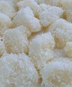 some kind of food that is sitting on a white tablecloth with coconut flakes all over it