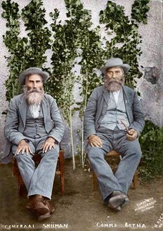 two men sitting next to each other in suits and hats with ivy growing on the wall behind them